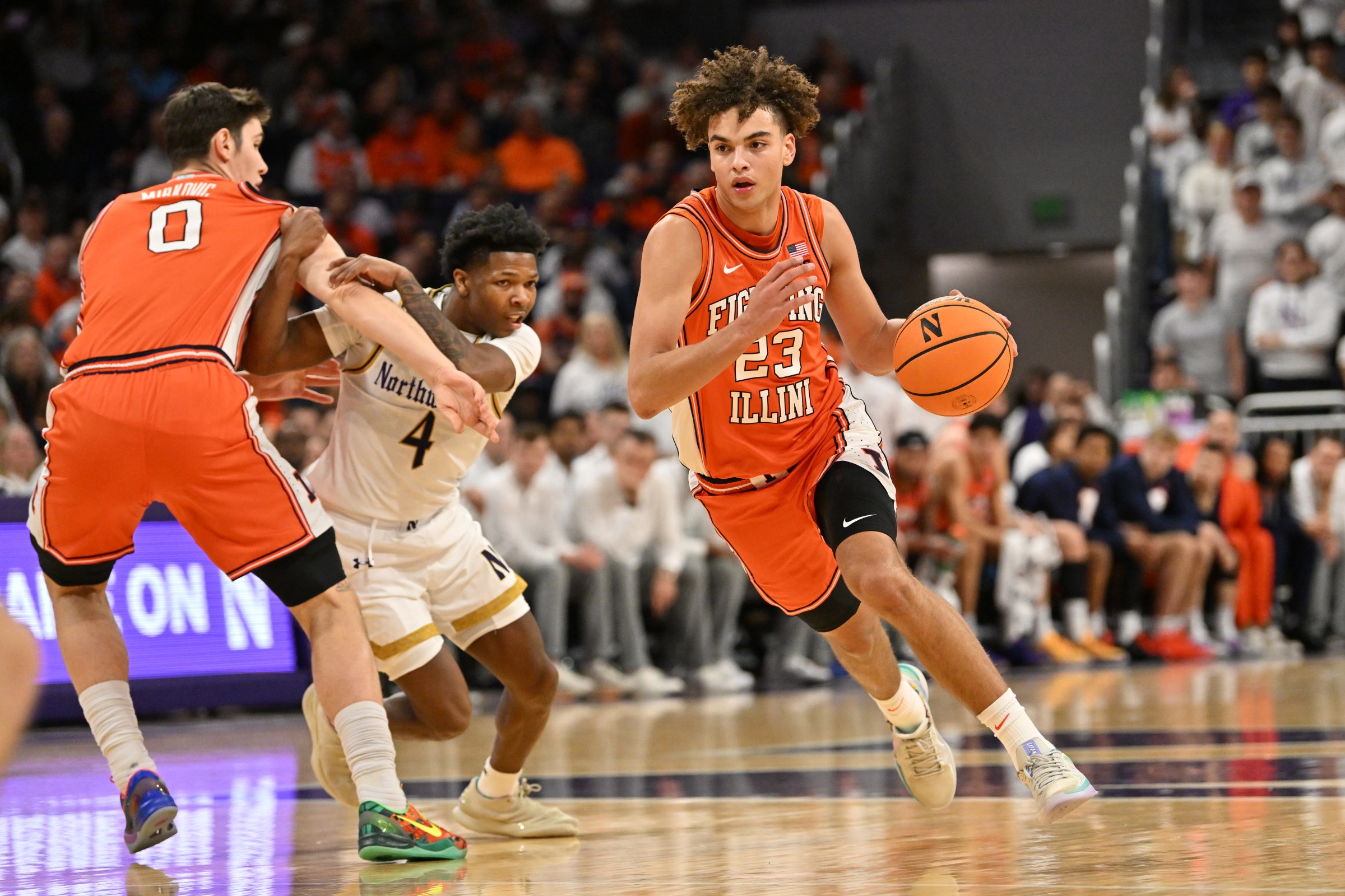 EVANSTON, IL - JANUARY 14: Illinois Fighting Illini guard Keaton Wagler (23) drives against Northwestern Wildcats guard Jayden Reid (4) as Illinois Fighting Illini forward David Mirkovic (0) defends during a college basketball game between the Illinois Fighting Illini and the Northwestern Wildcats on January 14, 2026, at Welsh-Ryan Arena in Evanston, IL. (Photo by Patrick Gorski/Icon Sportswire via Getty Images)