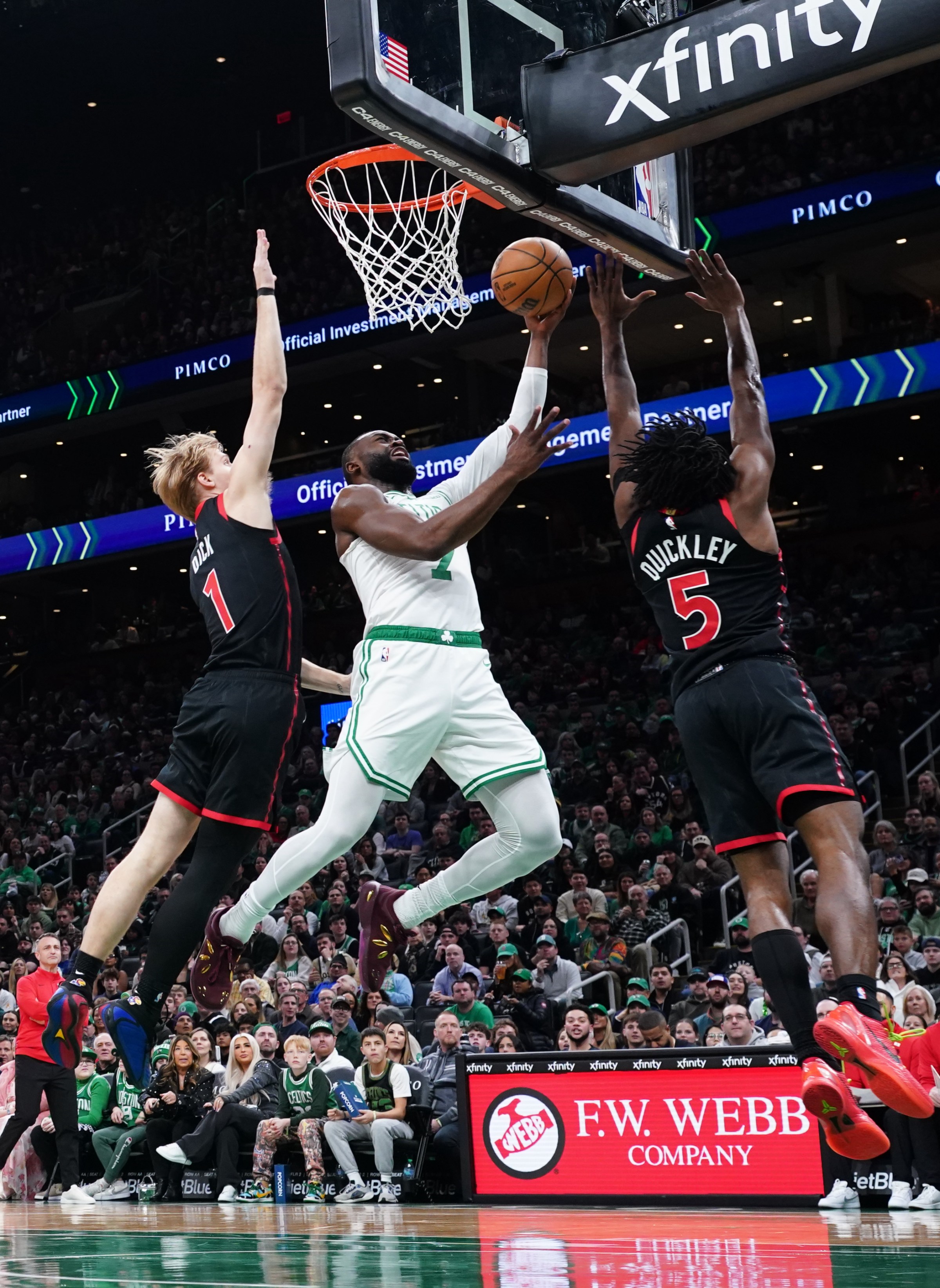 Jan 9, 2026; Boston, Massachusetts, USA; Boston Celtics guard Jaylen Brown (7) drives the ball to the basket against Toronto Raptors guard Immanuel Quickley (5) and guard Gradey Dick (1) in the first half at TD Garden. Mandatory Credit: David Butler II-Imagn Images