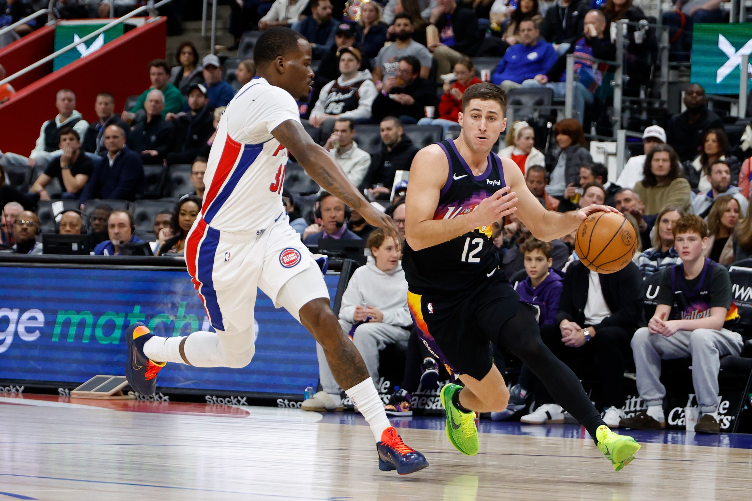 Jan 15, 2026; Detroit, Michigan, USA; Phoenix Suns guard Collin Gillespie (12) dribbles defended by Detroit Pistons guard Javonte Green (31) in the first half at Little Caesars Arena. Mandatory Credit: Rick Osentoski-Imagn Images
