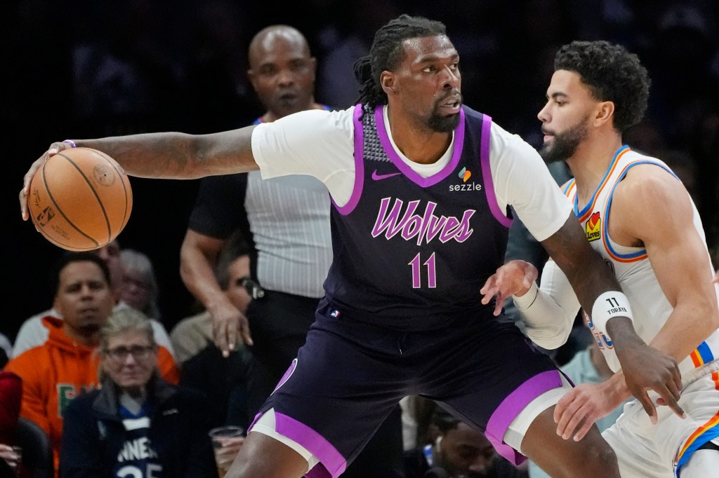 Timberwolves center Naz Reid (11) works around Oklahoma City Thunder guard Ajay Mitchell (25).