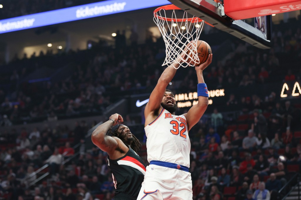 Karl-Anthony Towns, right, drives to the basket as Portland Trail Blazers center/forward Robert Williams III, left, defends during the first half of an NBA basketball game, Sunday, Jan. 11, 2026, in Portland, Ore.
