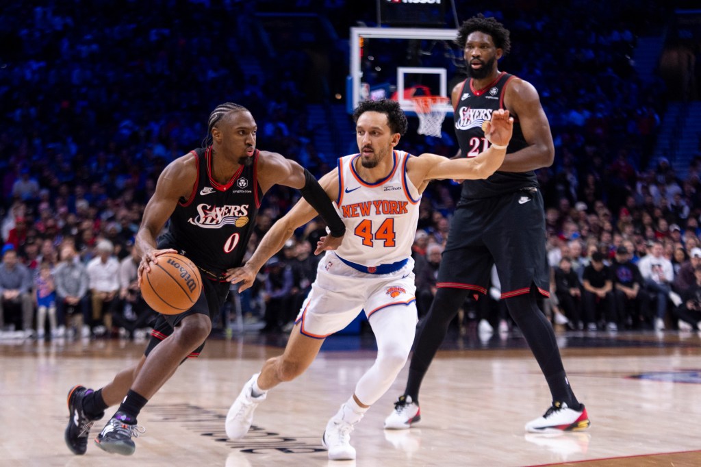 Philadelphia 76ers' Tyrese Maxey, left, drives to the basket with New York Knicks' Landry Shamet, center, defending during the second half of an NBA basketball game, Saturday, Jan. 24, 2026.