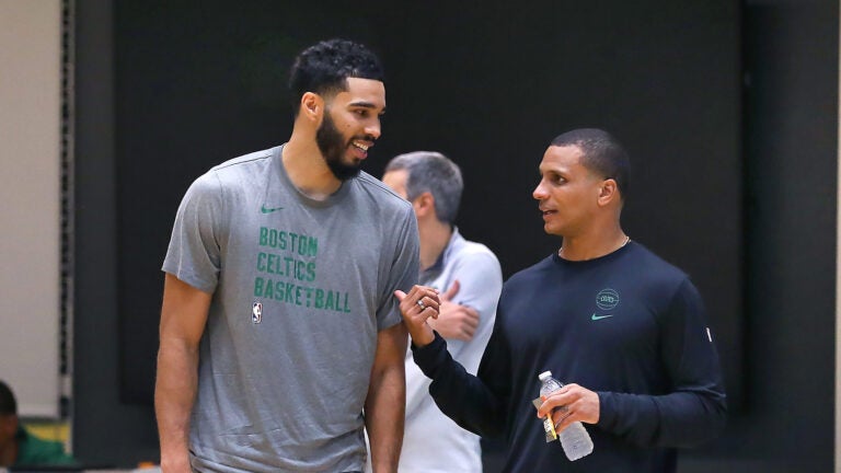 The Boston Celtics held their first day of training camp at the Auerbach center on Tuesday. Jayson Tatum(left) chats with coach Joe Mazzulla on the court.