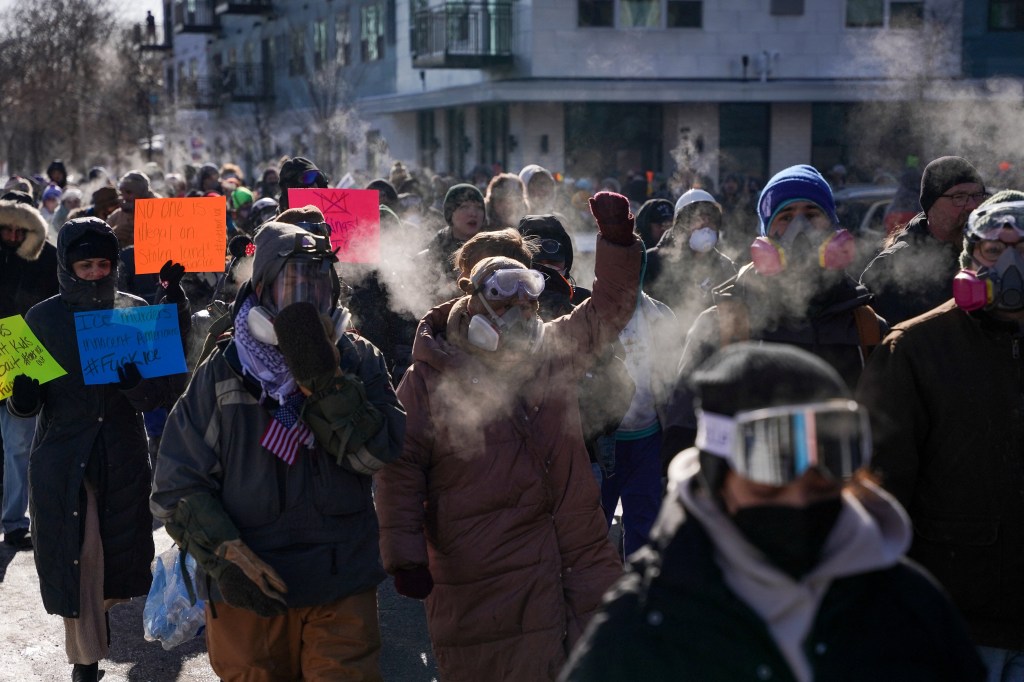 People holding placards and wearing respirators during a demonstration in Minneapolis.