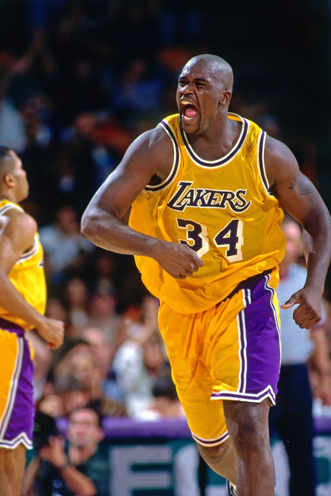 Shaquille O'Neal in a yellow and purple Lakers uniform, yelling on the court.