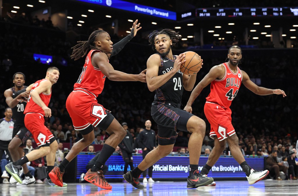 Brooklyn Nets' Cam Thomas #24 looks for a pass as Chicago Bulls' Ayo Dosunmu #11 defends him.