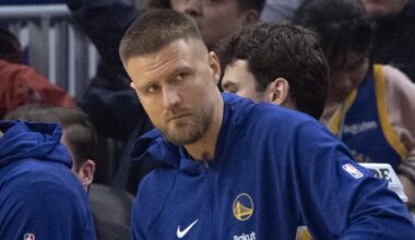 Feb 19, 2026; San Francisco, California, USA; New Golden State Warriors forward Kristaps Porzingis (with towel) watches the action against the Boston Celtics from the bench during the first quarter at Chase Center. Mandatory Credit: D. Ross Cameron-Imagn Images