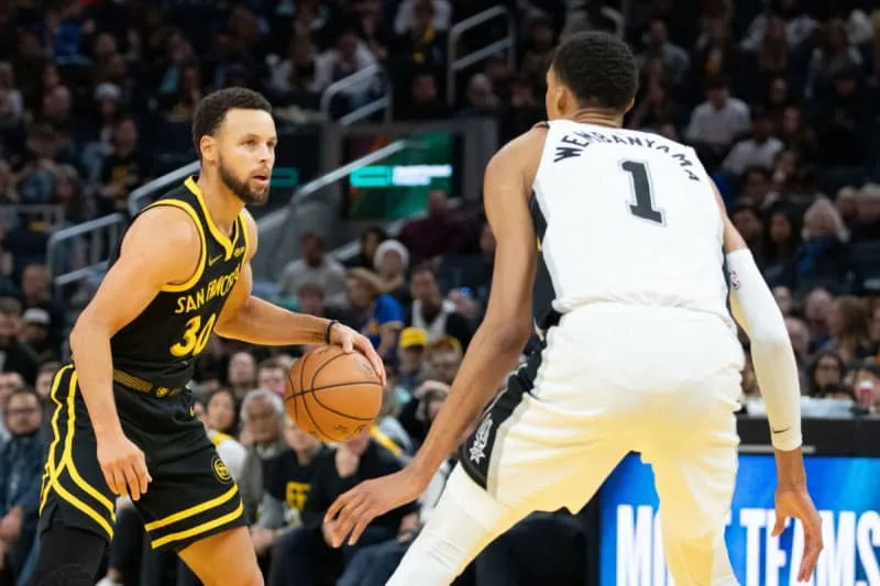 November 24, 2023; San Francisco, California, USA; Golden State Warriors guard Stephen Curry (30) dribbles the basketball against San Antonio Spurs center Victor Wembanyama (1) during the fourth quarter at Chase Center. Mandatory Credit: Kyle Terada-USA TODAY Sports
