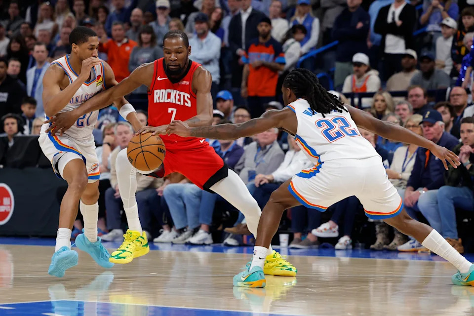 Feb 7, 2026; Oklahoma City, Oklahoma, USA; Houston Rockets forward Kevin Durant (7) drives between Oklahoma City Thunder guard Aaron Wiggins (21) and guard Cason Wallace (22) during the second half at Paycom Center. Mandatory Credit: Alonzo Adams-Imagn Images