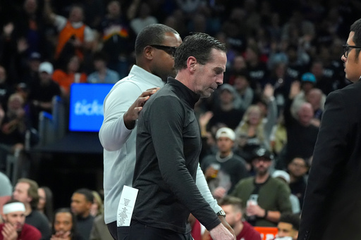 Cleveland Cavaliers head coach Kenny Atkinson is escorted off the court after being ejected for getting his second technical foul during the second half of an NBA basketball game against the Phoenix Suns Friday, Jan. 30, 2026, in Phoenix. (AP Photo/Ross D. Franklin)