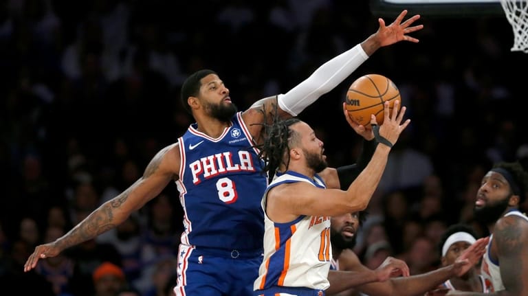 Philadelphia 76ers forward Paul George, left, defends the shot of...