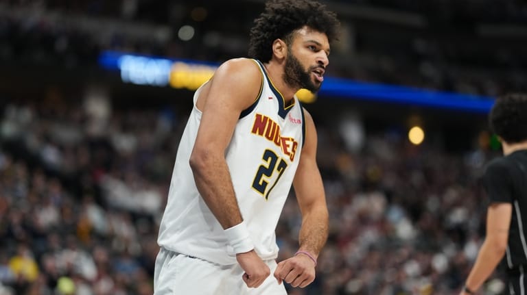 Denver Nuggets guard Jamal Murray reacts after dunking the ball...
