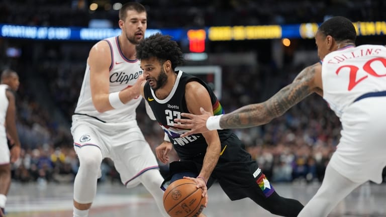 Denver Nuggets guard Jamal Murray, center, drives to the basket...