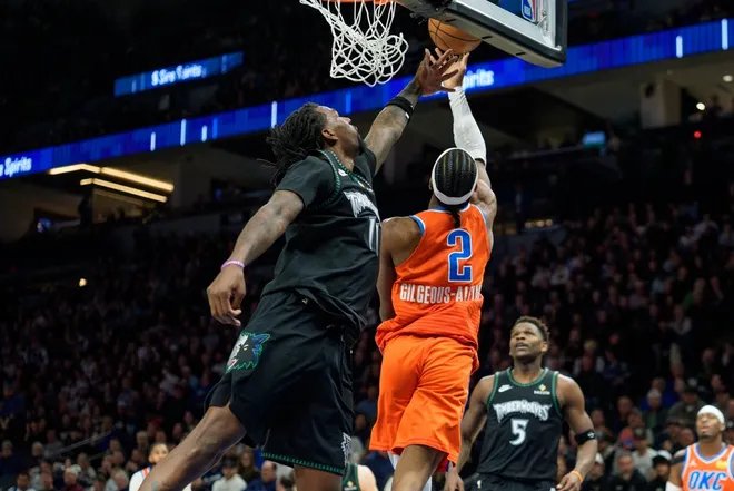 Jan 29, 2026; Minneapolis, Minnesota, USA; Oklahoma City Thunder guard Shai Gilgeous-Alexander (2) shoots over the defense of Minnesota Timberwolves center Naz Reid (11) in the fourth quarter at Target Center.