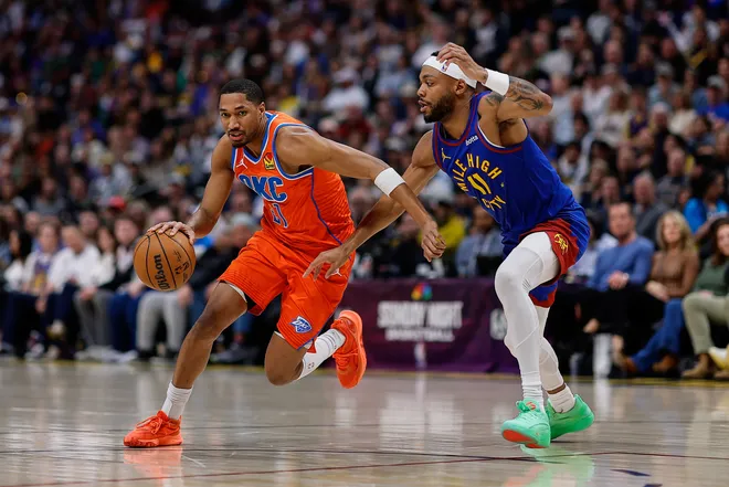 Feb 1, 2026; Denver, Colorado, USA; Oklahoma City Thunder guard Aaron Wiggins (21) controls the ball as Denver Nuggets guard Tim Hardaway Jr. (10) guards in the first quarter at Ball Arena. Mandatory Credit: Isaiah J. Downing-Imagn Images