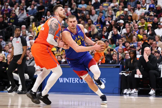 DENVER, COLORADO - FEBRUARY 01: Nikola Jokic #15 of the Denver Nuggets drives against Isaiah Hartenstein #55 of the Oklahoma City Thunder during the first quarter at Ball Arena on February 1, 2026 in Denver, Colorado. NOTE TO USER: User expressly acknowledges and agrees that, by downloading and or using this photograph, User is consenting to the terms and conditions of the Getty Images License Agreement. (Photo by Justin Tafoya/Getty Images)