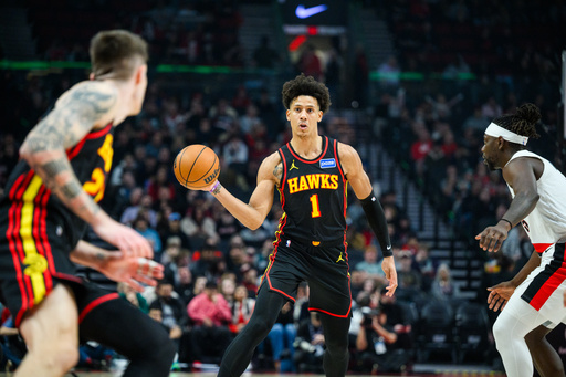Atlanta Hawks forward Jalen Johnson (1), center, dishes a pass to Atlanta Hawks guard Vit Krejci, left, during the first half of an NBA basketball game against the Portland Trail Blazers on Thursday, Jan. 15, 2026, in Portland, Ore. (AP Photo/Molly J. Smith)