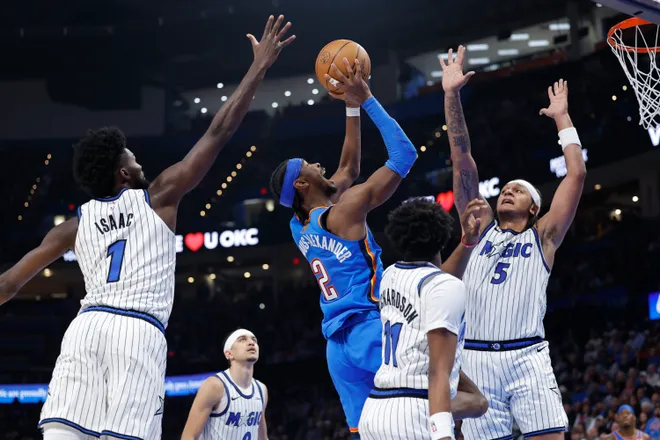 Feb 3, 2026; Oklahoma City, Oklahoma, USA; Oklahoma City Thunder guard Shai Gilgeous-Alexander (2) shoots between Orlando Magic forward Jonathan Isaac (1) and Orlando Magic guard Jase Richardson (11) and Orlando Magic forward Paolo Banchero (5) during the second half at Paycom Center. Mandatory Credit: Alonzo Adams-Imagn Images