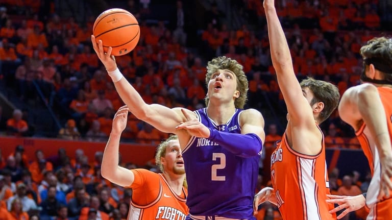 Northwestern's Nick Martinelli drives to the basket as Illinois' Jake...