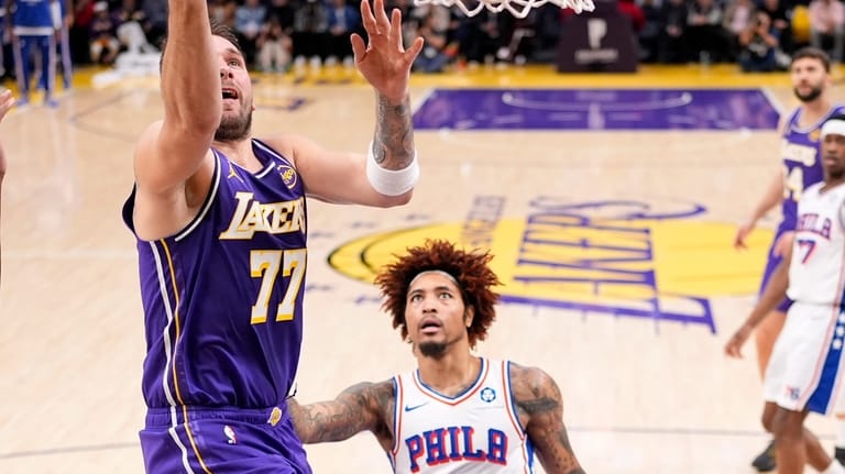 Los Angeles Lakers guard Luka Doncic, left shoots as Philadelphia...