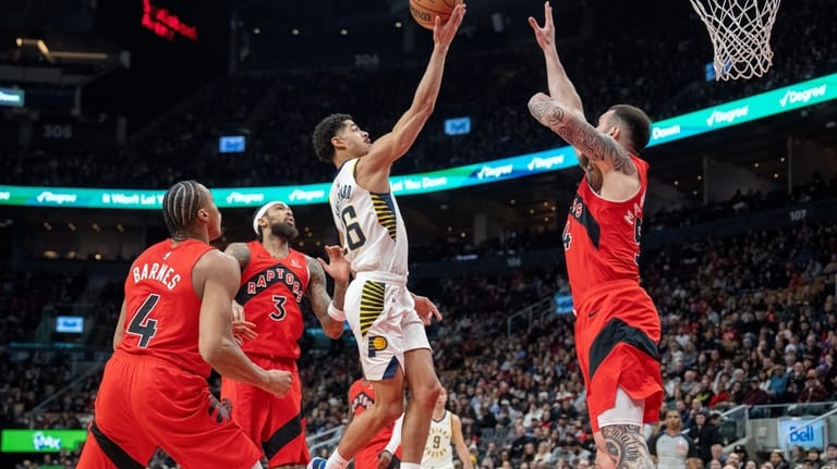 Indiana Pacers guard Ben Sheppard, center, goes to the hoop...