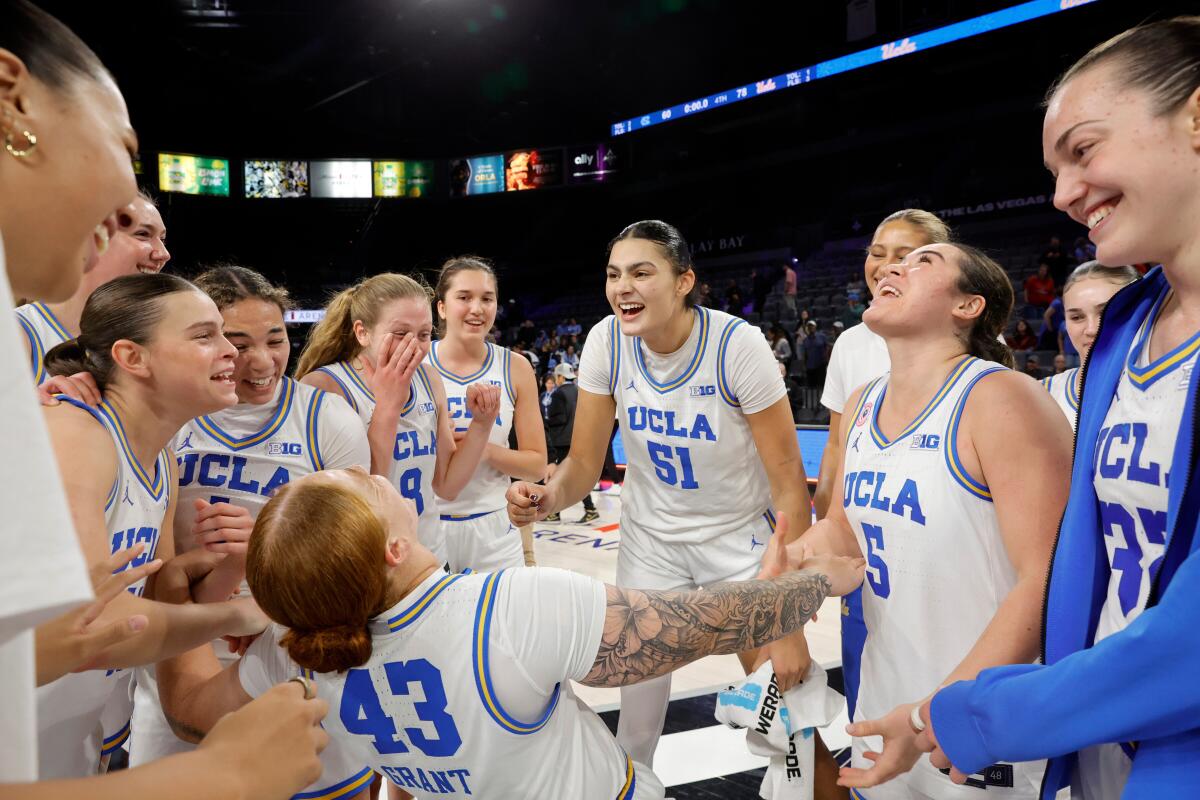 UCLA forward Megan Grant is surrounded by teammates while celebrating after a win over North Carolina in Las Vegas.