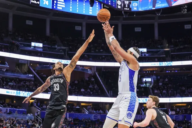 Feb 5, 2026; Orlando, Florida, USA; Orlando Magic forward Paolo Banchero (5) shoots against Brooklyn Nets center Nic Claxton (33) during the second half at Kia Center.