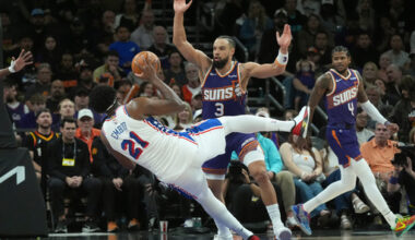 Philadelphia 76ers center Joel Embiid (21) is fouled by Phoenix Suns forward Dillon Brooks (3) as Suns guard Jalen Green (4) looks on during the second half of an NBA basketball game Saturday, Feb. 7, 2026, in Phoenix. (AP Photo/Ross D. Franklin)