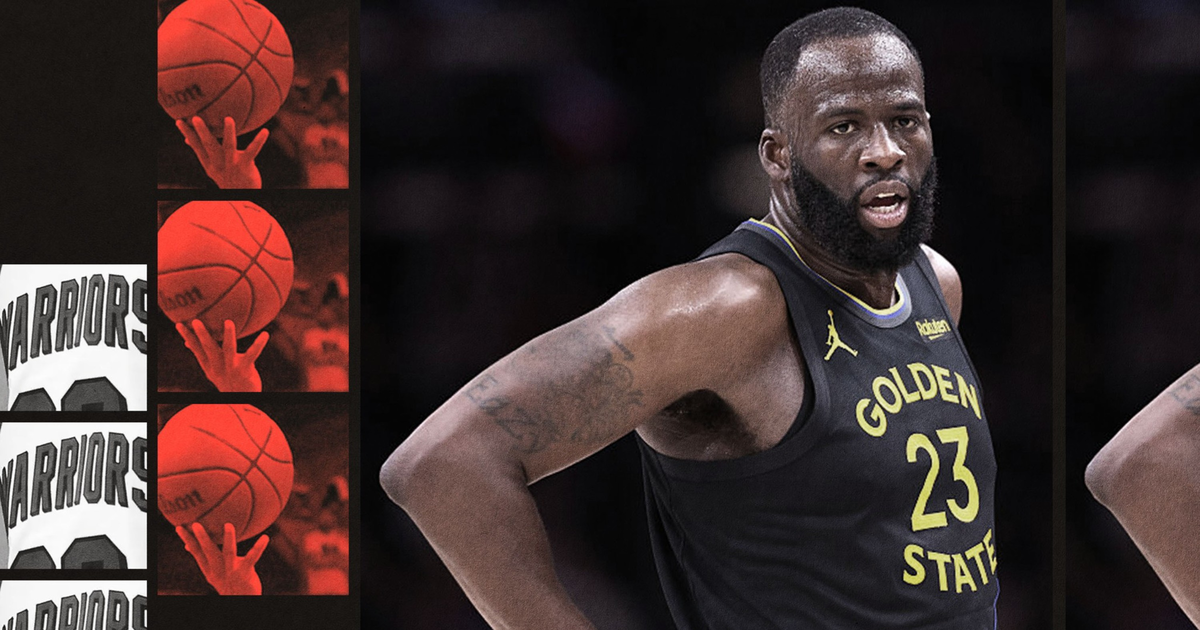 A basketball player wearing a black Golden State jersey with number 23 stands with his hand on his hip, looking focused.