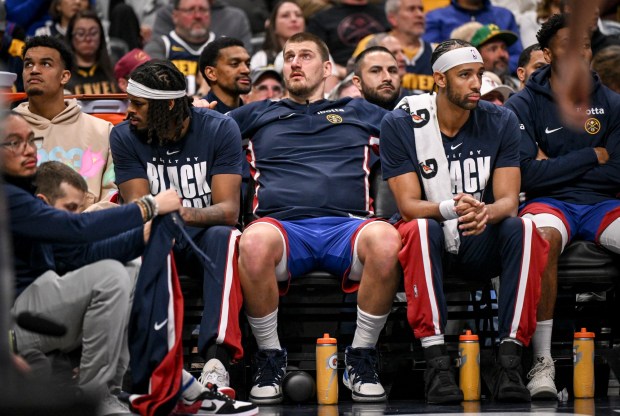 Nikola Jokic (15) of the Denver Nuggets sits between Daron Holmes II (14) and Zeke Nnaji (22) during the fourth quarter of the Cleveland Cavaliers' 119-117 win at Ball Arena in Denver, Colorado on Monday, February 9, 2026. (Photo by AAron Ontiveroz/The Denver Post)