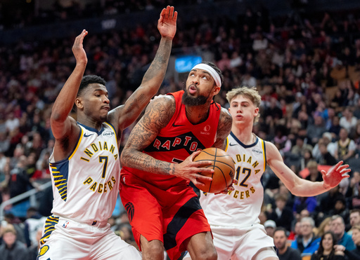 Toronto Raptors forward Brandon Ingram, center, works his way to the hoop past Indiana Pacers guard Kam Jones (7) and Johnny Furphy (12) during second-half NBA basketball game action in Toronto, Sunday Feb. 8, 2026. (Frank Gunn/The Canadian Press via AP)