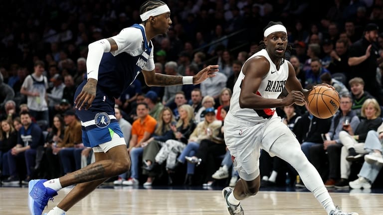 Portland Trail Blazers guard Jrue Holiday, right, works around Minnesota...