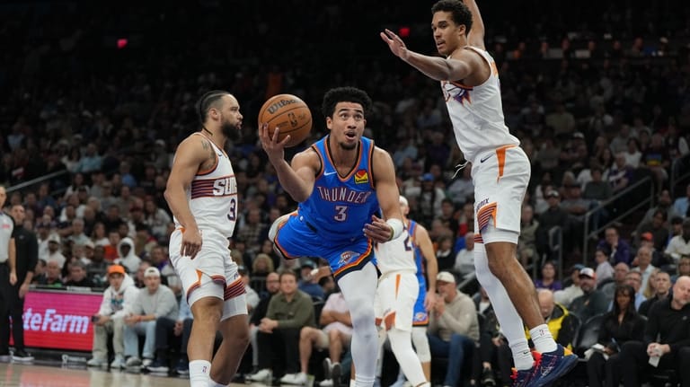 Oklahoma City Thunder guard Jared McCain scores between Phoenix Suns...