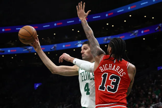 Feb 11, 2026; Boston, Massachusetts, USA; Boston Celtics center Nikola Vucevic (4) passes around Chicago Bulls center Nick Richards (13) during the first quarter at TD Garden. Mandatory Credit: Winslow Townson-Imagn Images