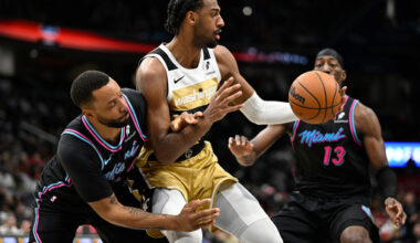 Washington Wizards center Alex Sarr, attempts to escape the defense of Miami Heat guard Terry Rozier, left, and Heat center Bam Adebayo (13) during the first half of an NBA basketball game, Sunday, Feb. 8, 2026, in Washington. (AP Photo/John McDonnell)