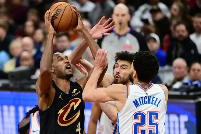 Jan 19, 2026; Cleveland, Ohio, USA; Cleveland Cavaliers center Evan Mobley (4) drives to the basket against Oklahoma City Thunder center Chet Holmgren (7) and guard Ajay Mitchell (25) during the second half at Rocket Arena.