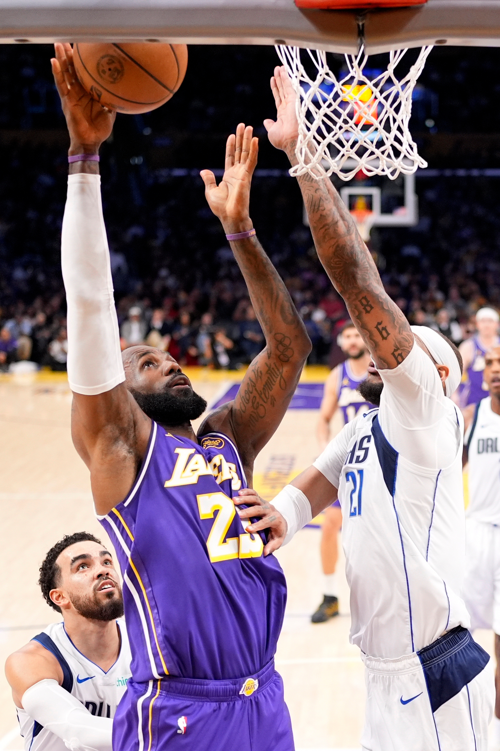 Lakers forward LeBron James, center, shoots as Dallas Mavericks forward...