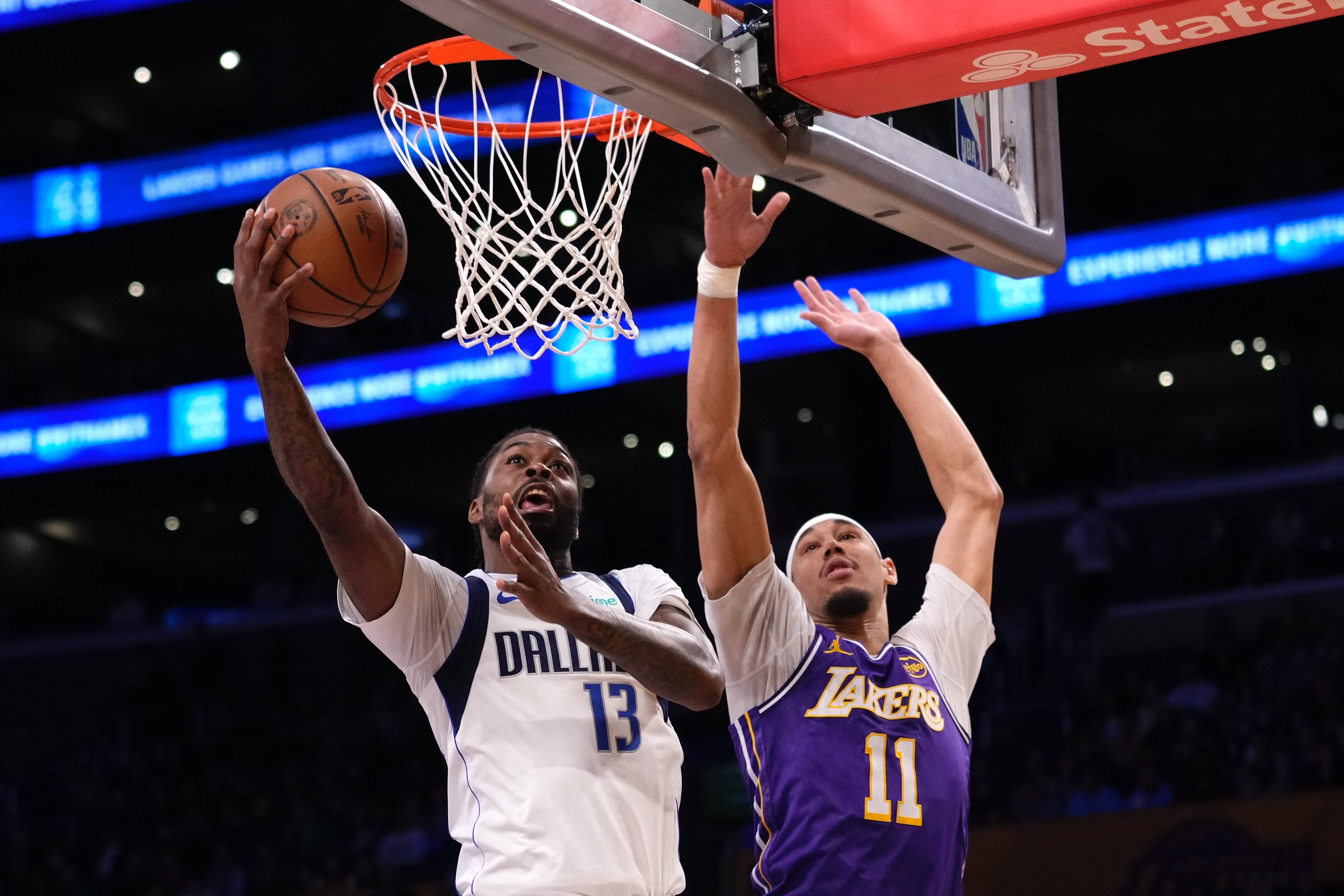 Dallas Mavericks forward Naji Marshall, left, shoots as Lakers center...
