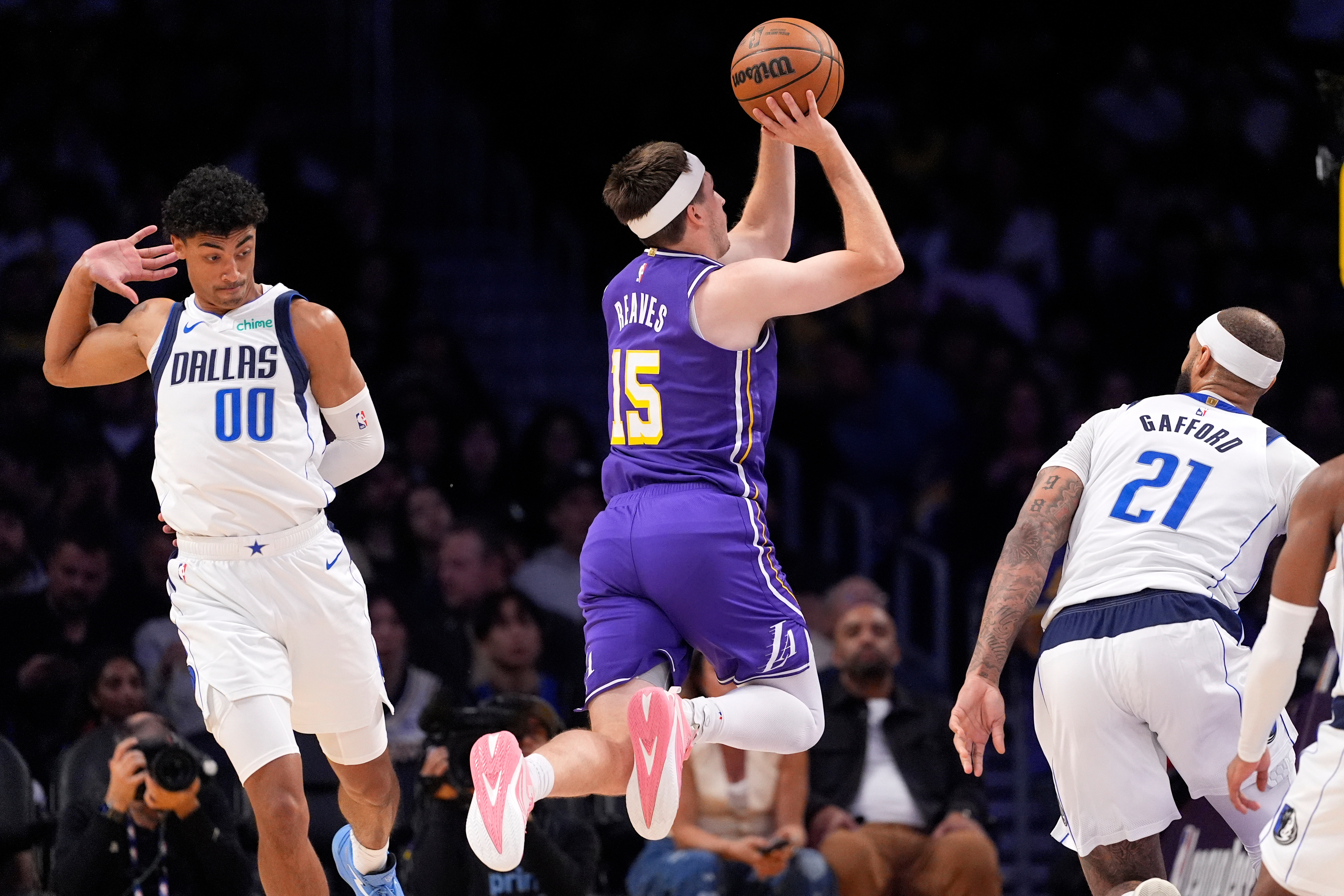 Lakers guard Austin Reaves, center, shoots as Dallas Mavericks guard...
