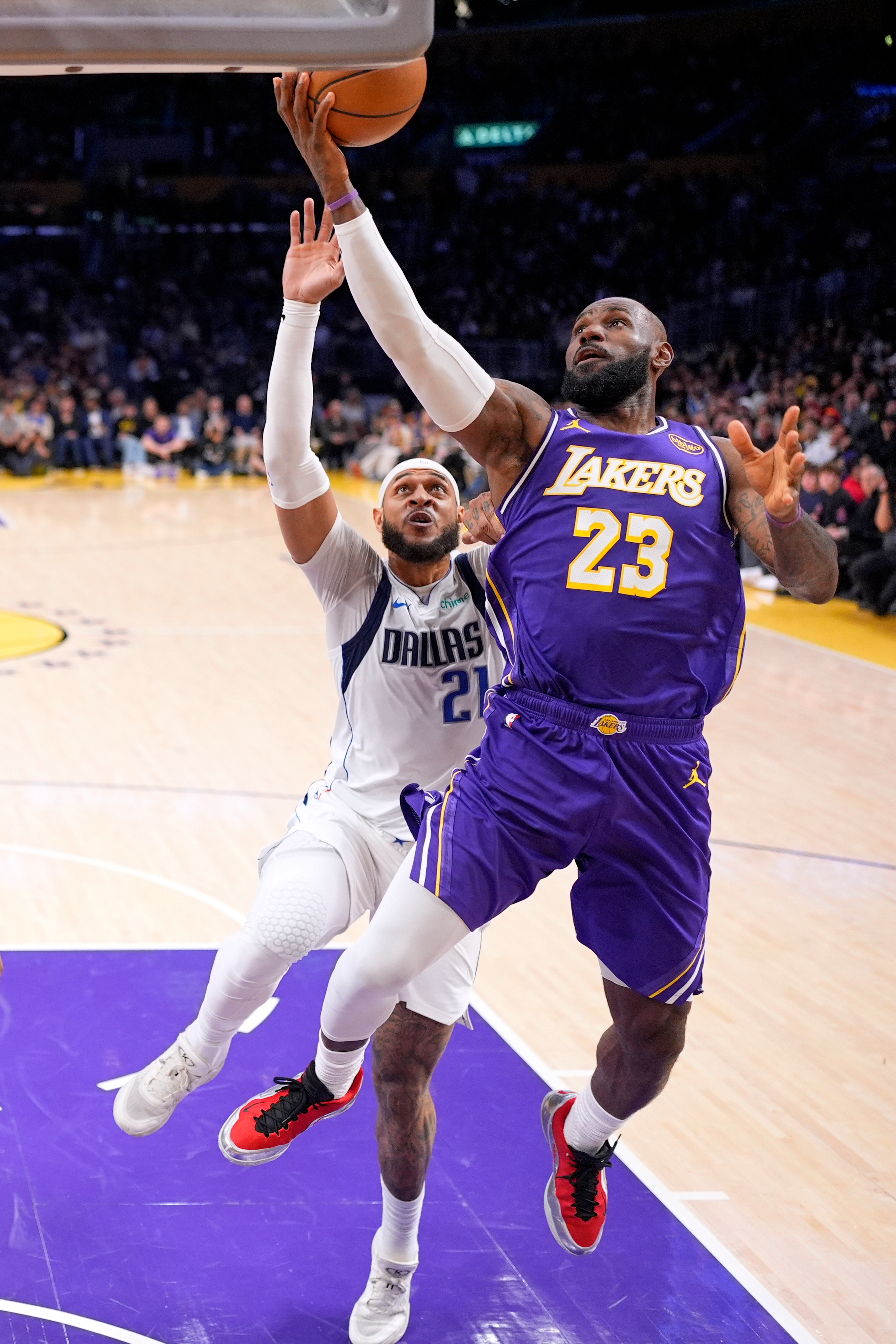 Lakers forward LeBron James, right, shoots as Dallas Mavericks forward...