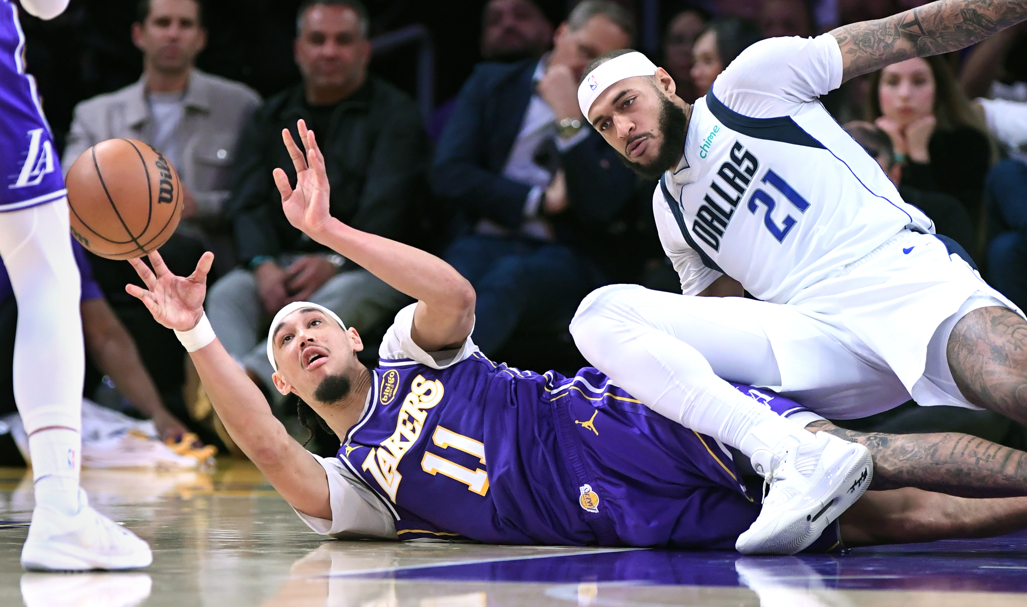 Lakers center Jaxson Hayes passes the ball while lying on...