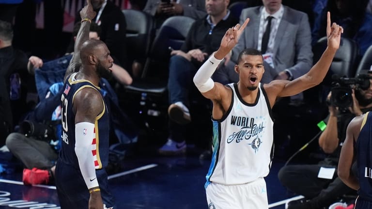 World center Victor Wembanyama, of France, reacts next to USA...