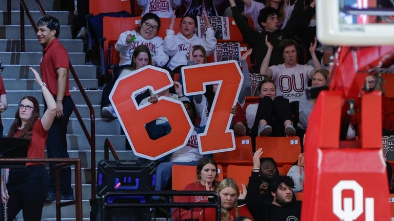Oklahoma fans hold up a giant 6-7 sign during the...