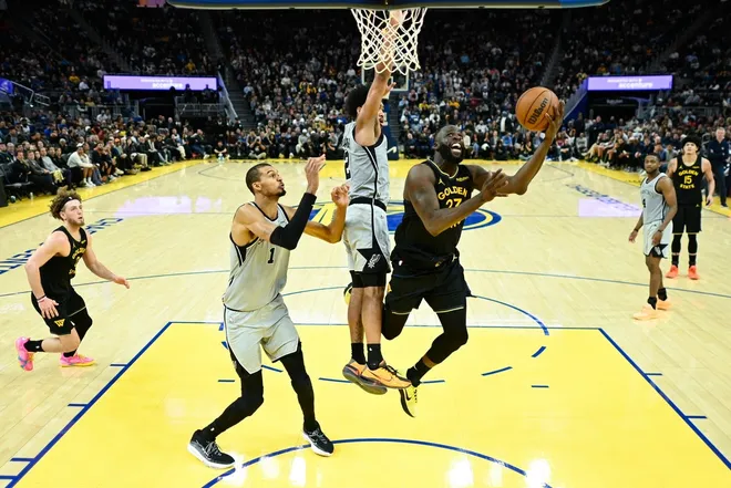 Feb 11, 2026; San Francisco, California, USA; Golden State Warriors forward Draymond Green (23) shoots against San Antonio Spurs guard Dylan Harper (2) and forward Victor Wembanyama (1) in the fourth quarter at Chase Center.