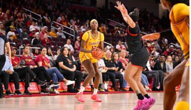 Jazzy Davidson wearing a gold jersey dribbles past a defender.