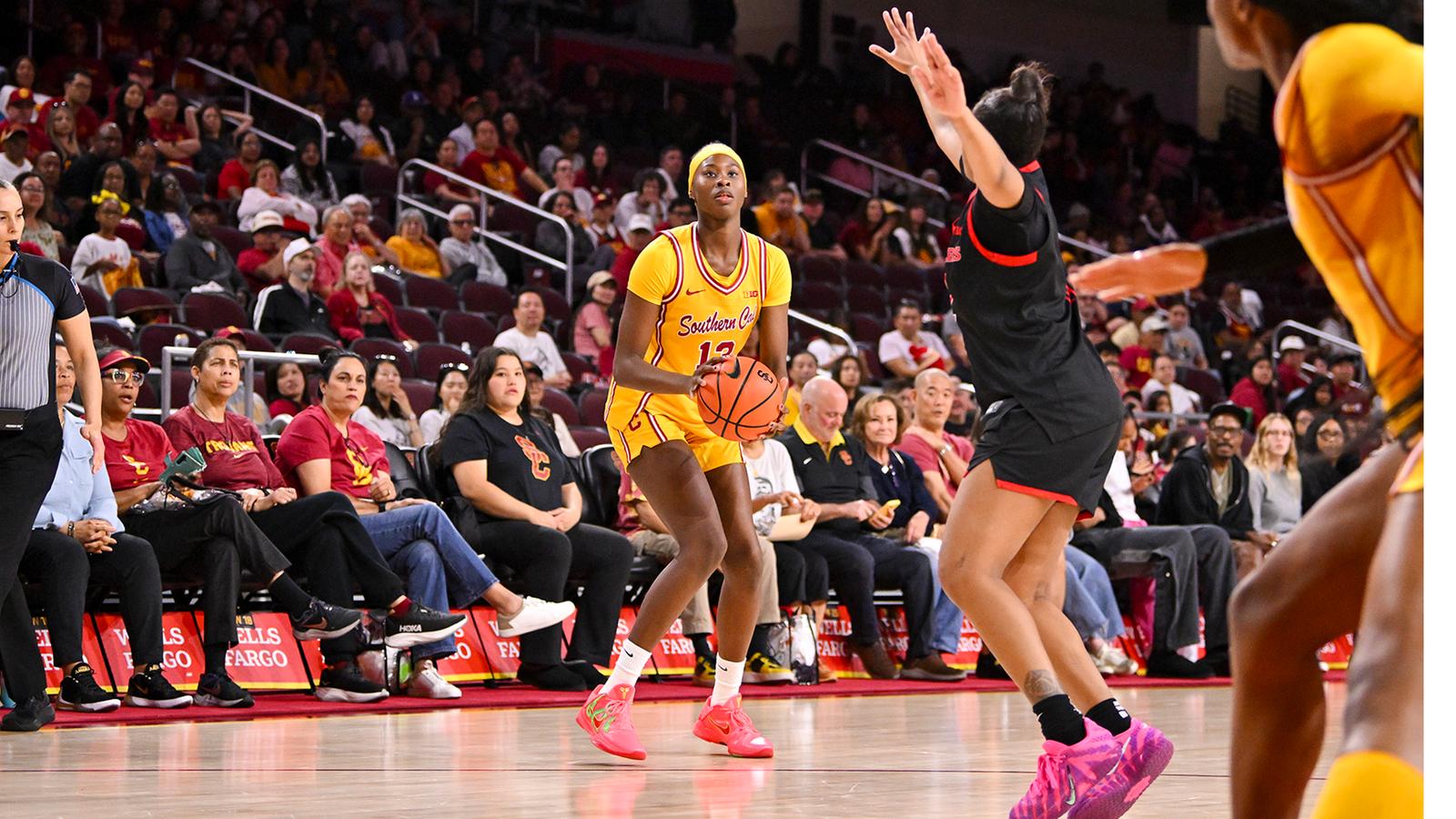 Jazzy Davidson wearing a gold jersey dribbles past a defender.