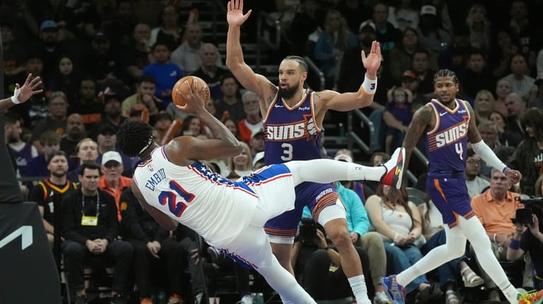 Philadelphia 76ers center Joel Embiid (21) is fouled by Phoenix...