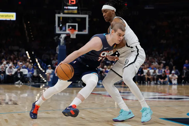 Feb 20, 2026; Oklahoma City, Oklahoma, USA; Oklahoma City Thunder guard Nikola Topić (44) drives past Brooklyn Nets guard/forward Terance Mann (14) during the second half at Paycom Center. Mandatory Credit: Alonzo Adams-Imagn Images