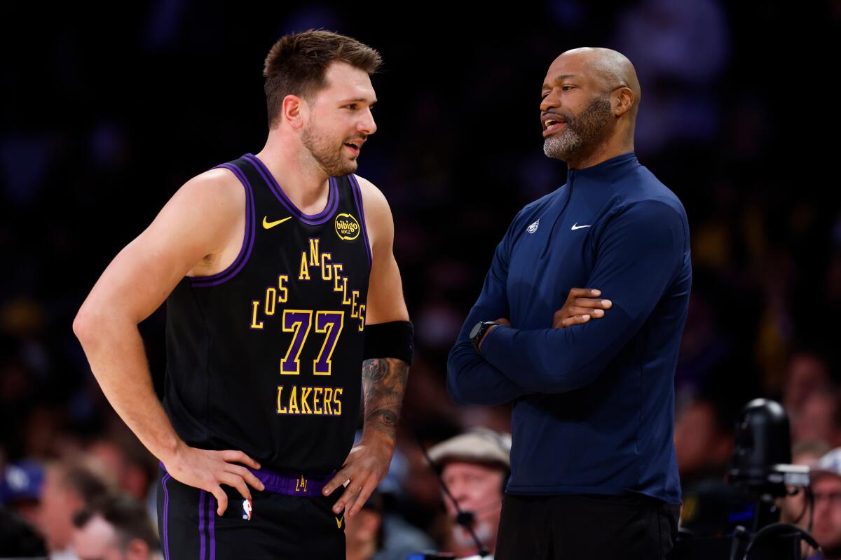 Luka Doncic and Orlando coach Jamahl Mosley talk during the first half.