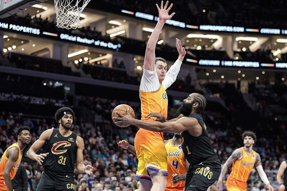 Cleveland Cavaliers guard James Harden (1) passes the ball around Charlotte Hornets center Ryan Kalkbrenner during the first half of an NBA basketball game, Friday, Feb. 20, 2026, in Charlotte, N.C.